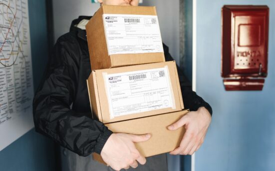 Picture of deliveryman holding packages to be delviered to a home.